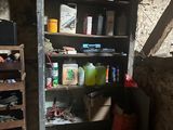 une bibliothèque dans un coin d'une pièce, sur laquelle sont posés de nombreux objets