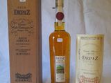 a bottle of depaz next to a box of wine