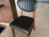 a black chair sitting in a restaurant next to a counter