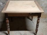 une petite table avec un plateau en bois sur un sol en ciment
