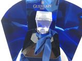 perfume bottle in a blue box with a blue ribbon around it