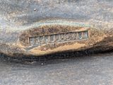 a close up of a metal object with a name on it