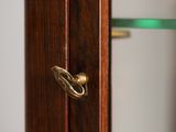 a close up of a wooden door with a glass shelf