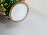 un vase orné d'un motif floral, posé sur une table