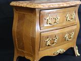 a small wooden chest of drawers on a black background