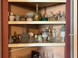 une vitrine dont les étagères sont remplies d'objets en verre