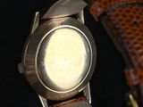 a close up of a watch on a black surface