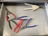 several pliers and pliers are in a metal box on a table