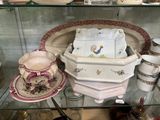 une vitrine en verre remplie d'assiettes et de tasses