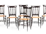 un lot de quatre chaises noires avec assise et dossier en bois