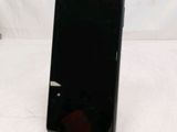 the back of a black cell phone sitting on top of a white table
