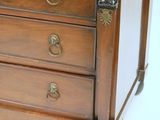 a small wooden chest of drawers with a clock on top of it