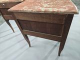 two wooden desks with marble tops on display