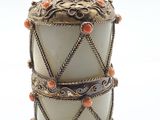 une image représentant un vase blanc surmonté de perles orange