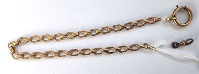 une chaîne en or à laquelle est accrochée une bague, avec une paire de ciseaux à côté