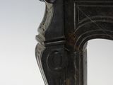 an antique cast iron fireplace surround with a black patt finish