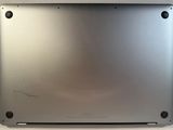 the back of a laptop with a silver cover on a white surface
