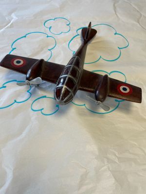 un petit avion en jouet posé sur une feuille de papier