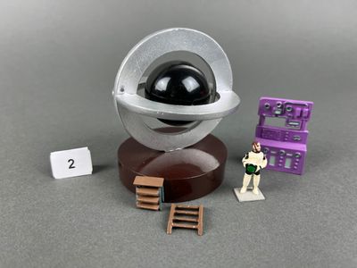 un jouet posé sur une table à côté d'un appareil photo