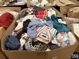 de nombreux cartons de vêtements qui traînent par terre