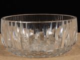a clear glass bowl sitting on a table with a black background