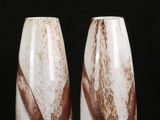 pair of wine glasses with brown and white swirls on a black background