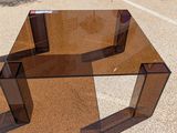 a glass table that is sitting in the middle of a parking lot