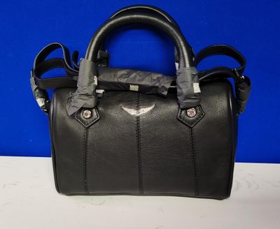 un sac à main en cuir noir posé sur une table blanche