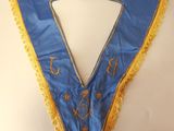 a close up of a blue and yellow collar on a white surface