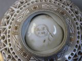 a white vase with a gold decoration on it