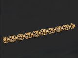 gros plan d'un bracelet en or sur fond noir