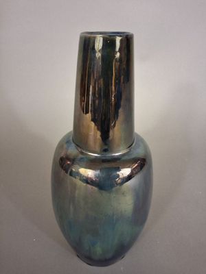 a silver vase sitting on a table with a white background
