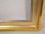 an image of a picture of a gold frame on a white wall