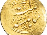 a close up of a gold coin with arabic writing on it