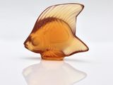 a glass figurine of a fish on a white surface