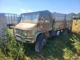 un camion rouillé garé dans l'herbe