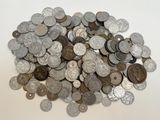 un tas d'argent et de pièces d'argent posé sur une surface blanche