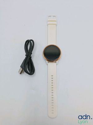 une montre connectée blanche avec un chargeur et un câble