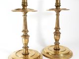 pair of antique brass candlesticks on stands on a white background