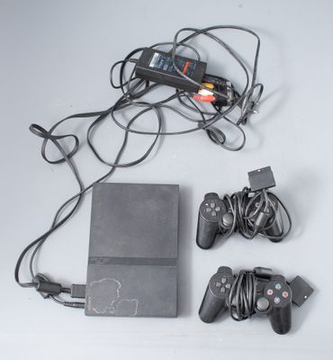 une console de jeux vidéo et deux manettes posées sur la table