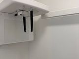 a white toilet in a small bathroom with a shelf above it