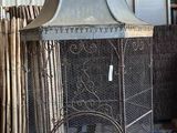 une cage à oiseaux sur laquelle est posé un oiseau
