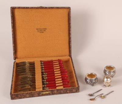 une boîte contenant des bougies et des cuillères argentées et rouges