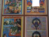 four framed pictures of asian art hanging on a wall in a room