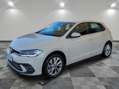 une Volkswagen Polo blanche garée dans une pièce au sol carrelé