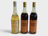 three bottles of wine sitting next to each other on a white surface