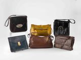quatre sacs à main différents sont alignés sur une surface blanche