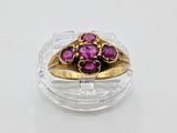 a gold ring with purple stones in it