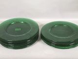 two green plates sitting on a white surface