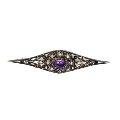 un gros plan sur une pierre violette sertie dans une broche en argent